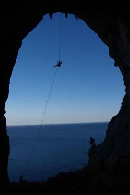 a person on a rope in a cave with the ocean at Holiday Home Haus in Kolympia mit Parkplatz und Bergblick by Interhome in Kolimbia