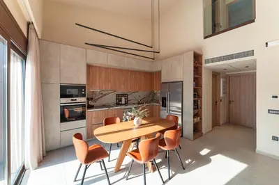 a kitchen with a wooden table and orange chairs at Estate Irianna 4 Bedroom Private Pool Villa & 2 Bedroom Guesthouse Rhodes in Ialyssos