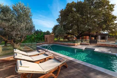 a swimming pool with two lounge chairs and a swimming poolvisor at Estate Irianna 4 Bedroom Private Pool Villa & 2 Bedroom Guesthouse Rhodes in Ialyssos