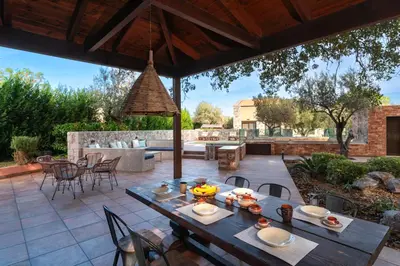 an outdoor patio with a table and chairs at Estate Irianna 4 Bedroom Private Pool Villa & 2 Bedroom Guesthouse Rhodes in Ialyssos