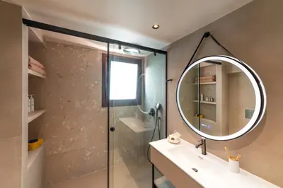 a bathroom with a shower and a sink and a mirror at Estate Irianna 4 Bedroom Private Pool Villa & 2 Bedroom Guesthouse Rhodes in Ialyssos