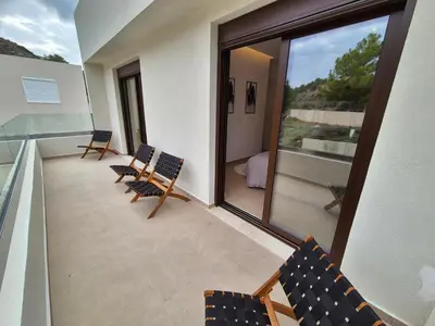 a balcony with chairs and a large glass window at Luxe nieuwe villa met zwembad in Kalithies