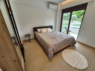 a bedroom with a bed and a large window at Luxe nieuwe villa met zwembad in Kalithies