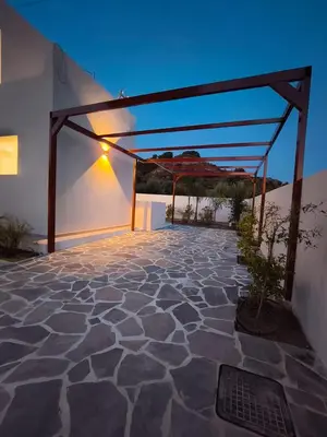 a patio with a canopy on the side of a building at Luxe nieuwe villa met zwembad in Kalithies