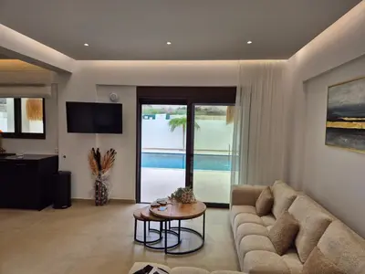 a living room with a couch and a table at Luxe nieuwe villa met zwembad in Kalithies