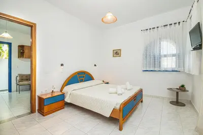 a bedroom with a bed and a tv in it at Anna's view Stegna in Vrachonisída touArchangélou