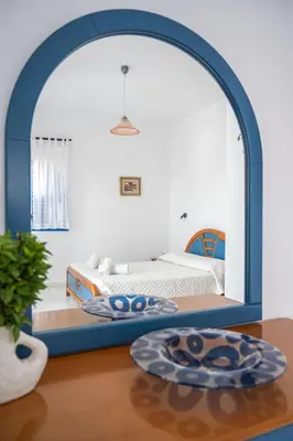 a room with a bed and a table with a mirror at Anna's view Stegna in Vrachonisída touArchangélou