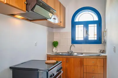 a kitchen with a sink and a blue window at Anna's view Stegna in Vrachonisída touArchangélou