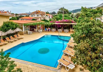 a pool at a hotel with chairs and tables at Paras Sun Hotel & Apartments in Ialyssos