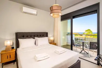 a bedroom with a bed with a view of the ocean at Villa Terra Magna Alba by Villa Plus in Gennadi