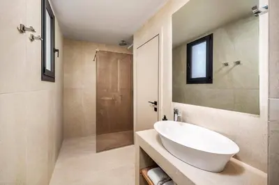 a bathroom with a white sink and a shower at Villa Terra Magna Alba by Villa Plus in Gennadi
