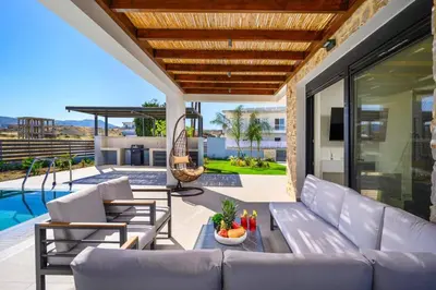 a patio with a couch and chairs and a pool at Villa Terra Magna Alba by Villa Plus in Gennadi