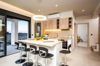 a kitchen with a island with bar stools at Villa Terra Magna Alba by Villa Plus in Gennadi