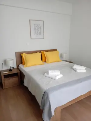 a bedroom with a large bed with yellow pillows at My Home in Ialyssos in Ialyssos