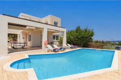 a swimming pool in front of a house at Villa Nicole Gennadi in Gennadi