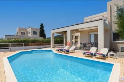 a swimming pool in front of a house at Villa Nicole Gennadi in Gennadi