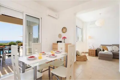 a dining room and living room with a table and chairs at Villa Nicole Gennadi in Gennadi