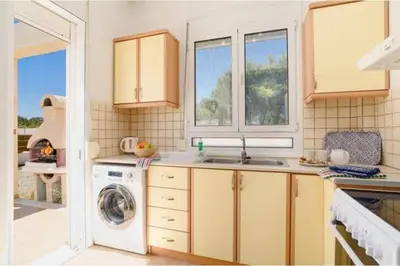 a kitchen with a sink and a washing machine at Villa Nicole Gennadi in Gennadi