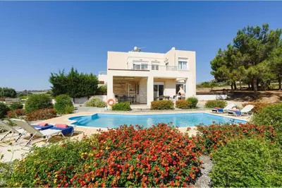 a villa with a swimming pool in front of a house at Villa Phoebe Gennadi in Gennadi