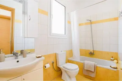 a bathroom with a toilet and a sink and a tub at Villa Phoebe Gennadi in Gennadi