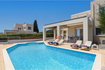 a swimming pool in front of a house at Villa Phoebe Gennadi in Gennadi
