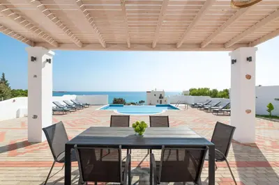 a patio with a table and chairs and a pool at Pefkos Sea Serenity Villas in Líndos