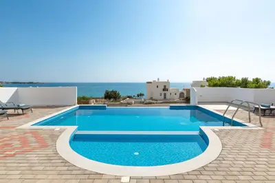 a swimming pool with a view of the ocean at Pefkos Sea Serenity Villas in Líndos