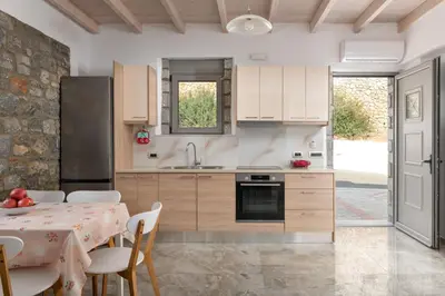 a kitchen with a table and a kitchen with a table and chairs at Pefkos Sea Serenity Villas in Líndos