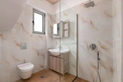 a bathroom with a shower and a toilet and a sink at Pefkos Sea Serenity Villas in Líndos