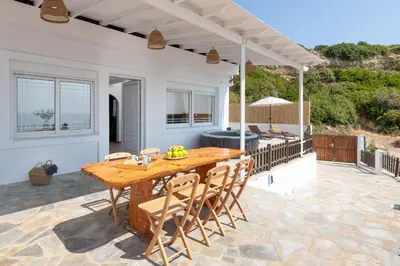 a wooden table and chairs on a patio at Oniro Beach House in Archangelos