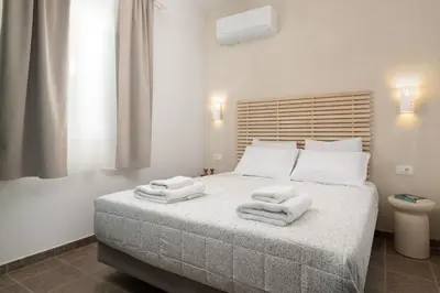 a bedroom with a bed with towels on it at Oniro Beach House in Archangelos