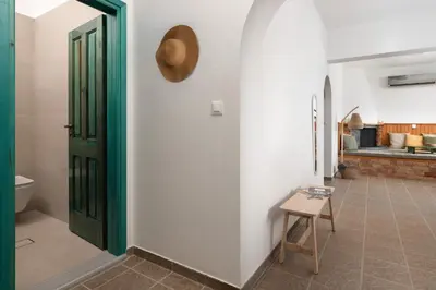 a room with a green door and a stool at Oniro Beach House in Archangelos