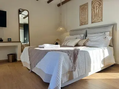 a bedroom with a large white bed with a mirror at Yucca Calma in Líndos