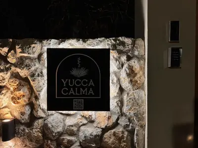 a sign on top of a stone wall at Yucca Calma in Líndos
