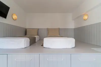 a bedroom with two beds and a flat screen tv at Lindos 4 me Villa in Líndos