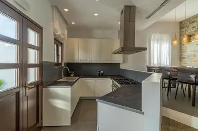 a kitchen with white cabinets and a counter top at Lindos 4 me Villa in Líndos