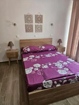 a bedroom with a bed with a purple comforter at Pension Annoula in Archangelos