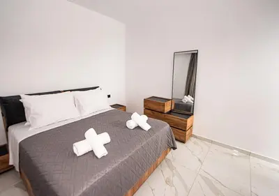 a bedroom with a bed with white crosses on it at Sinani Villas Rhodes in Afantou