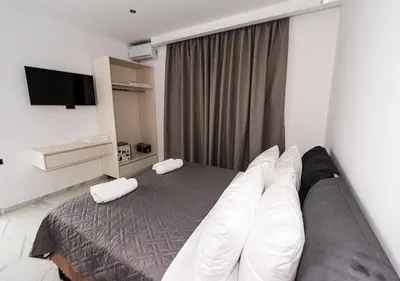 a hotel room with a bed with white pillows at Sinani Villas Rhodes in Afantou
