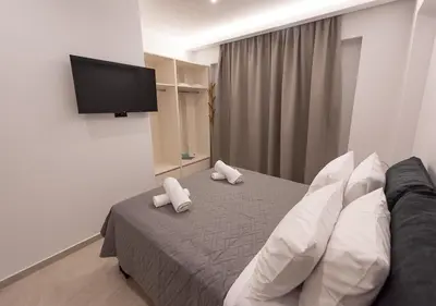 a bedroom with a bed and a flat screen tv at Sinani Villas Rhodes in Afantou