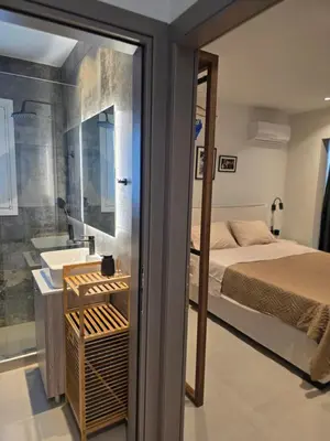 a bedroom with a bed and a sink and a mirror at Casa Bronx luxury apartment in Rhodes Town