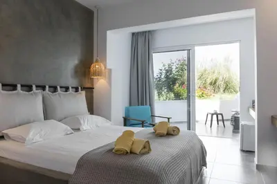 a bedroom with a bed with yellow towels on it at Hercules Plus in Faliraki