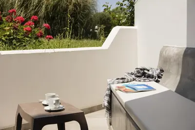 a table and a chair with a coffee cup on it at Hercules Plus in Faliraki