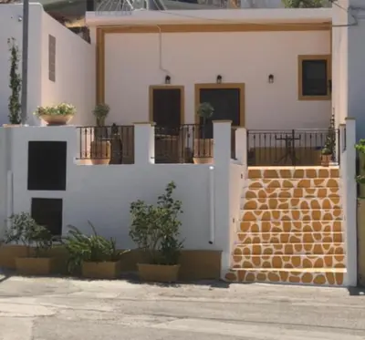 a white building with potted plants in front of it at Villa Savastoula in Phanaes
