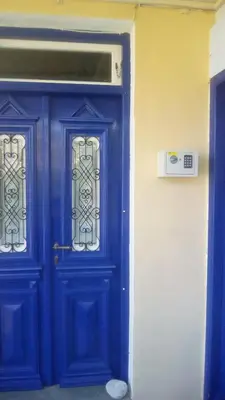 a blue door with two windows on a building at Symi Traditional Appartment in Symi
