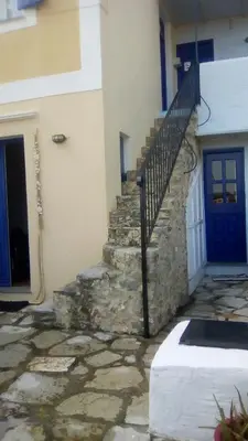 a building with a staircase and a blue door at Symi Traditional Appartment in Symi