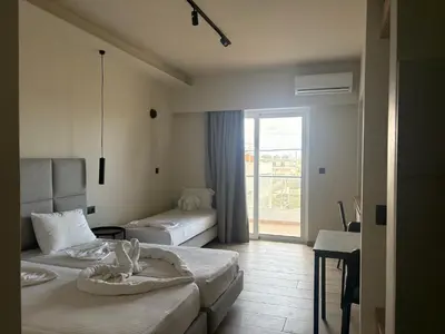 a hotel room with two beds and a balcony at Barbie II in Ialyssos