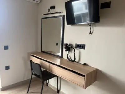 a desk with a mirror and a phone on a wall at Barbie II in Ialyssos