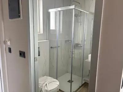 a bathroom with a glass shower with a toilet at Barbie II in Ialyssos