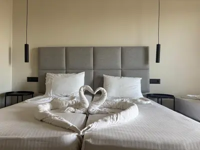 two swans are forming a heart on a bed at Barbie II in Ialyssos